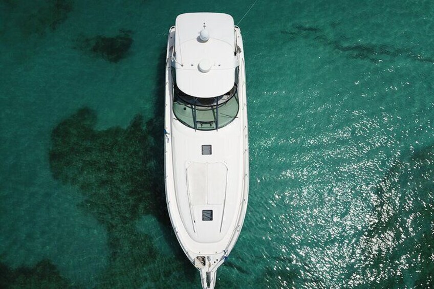 A white boat anchored in clear turquoise water. 2