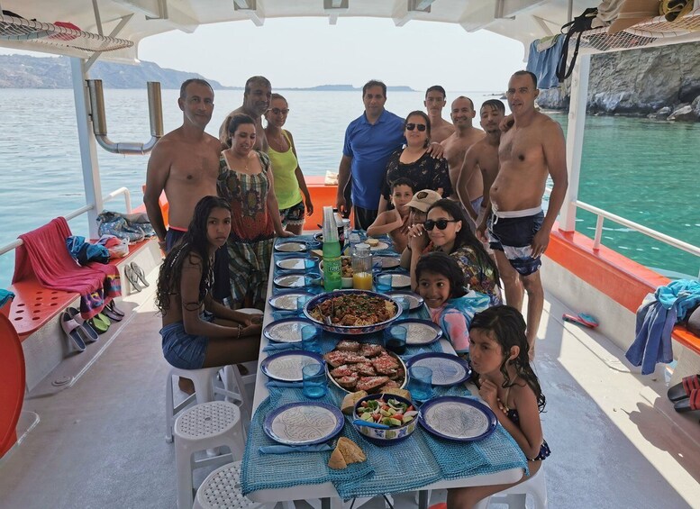Un gruppo di persone cena su una barca, con un tavolo apparecchiato con piatti, bicchieri e una bottiglia d'acqua. 5