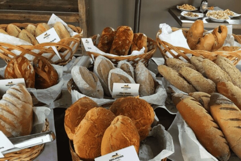 A variety of breads displayed in baskets with labels. 5