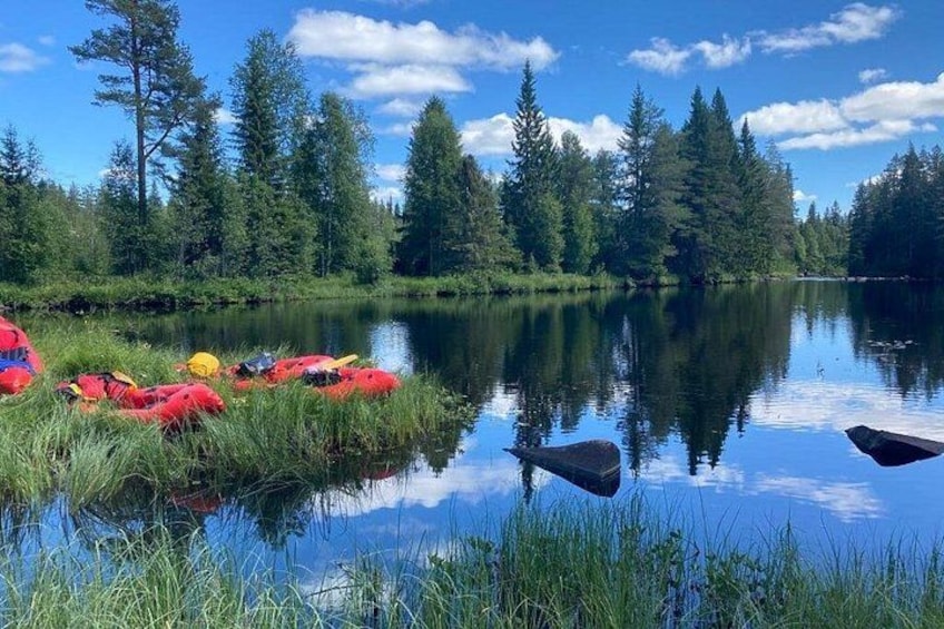 A calm river with kayaks and a forested area. 4