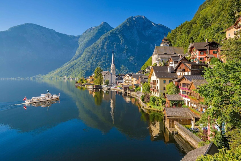 Un lago con una barca, una chiesa e case lungo la riva. 1