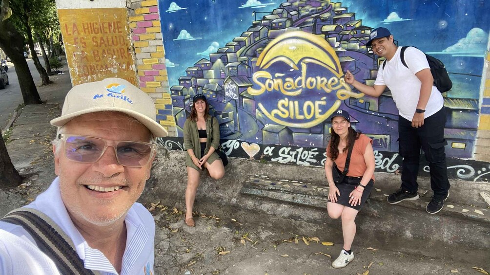 En mural med teksten 'Sonadores Siloe' og en person der tager en selfie. 3