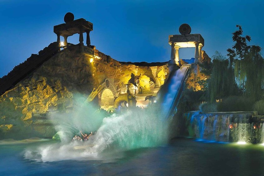 A water ride with a waterfall and illuminated statues. 2