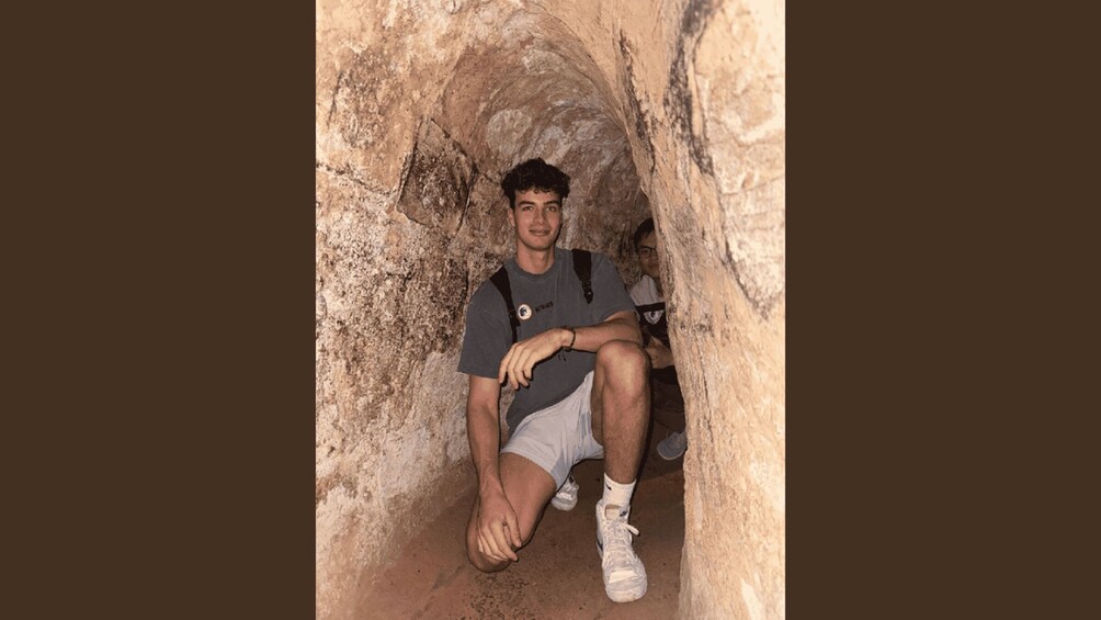 Una persona sentada en una cueva con una mochila. 3