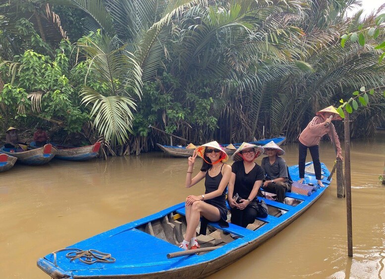 Un grupo de personas en una embarcación azul navegando por un río rodeado de exuberante vegetación tropical. 4