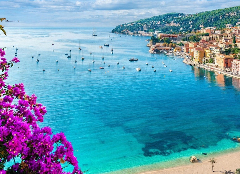 A coastal town with clear blue waters, boats, and a beach. 2