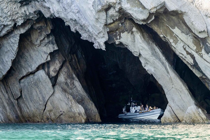 A boat entering a large rock cave. 5