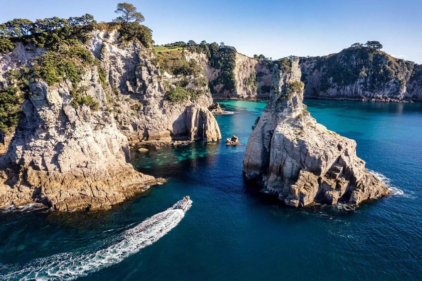 A coastal landscape with rocky cliffs and clear turquoise waters. 2