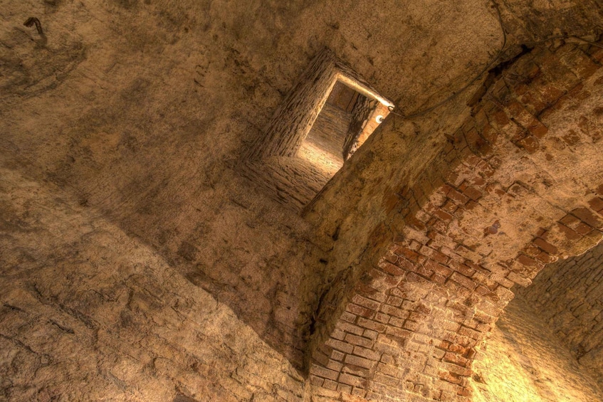 An ancient stone structure with a narrow passageway and a small window. 5
