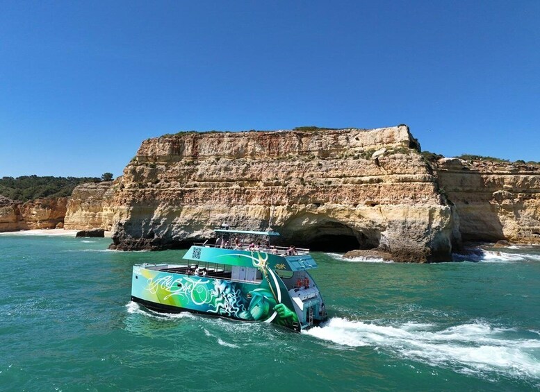 A boat with a dragon design sailing near a rocky coastline. 2