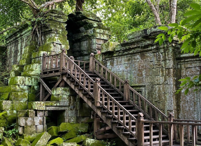 A stone staircase leading up to a temple entrance, surrounded by lush greenery. 4