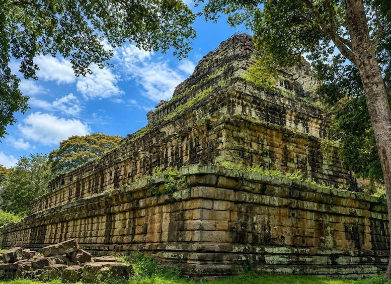 An ancient stone temple with intricate carvings, surrounded by lush greenery and trees. 5
