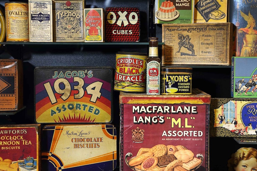 Vintage biscuit tins and boxes, including brands like Jacob's, Criddle's, and Macfarlane Lang's, displayed on shelves. 4