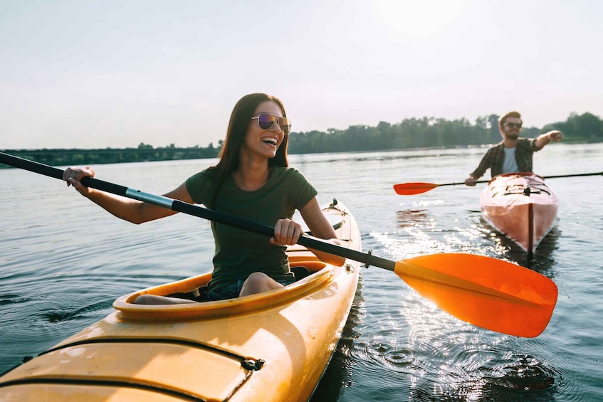 Two people kayaking on a calm river. 2