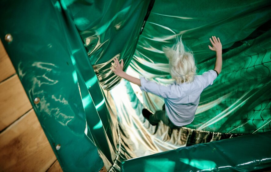 A person climbing a metallic spiral staircase. 4