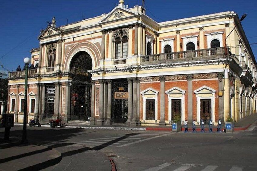 A historic building with classical architecture, a prominent entrance, and a street in front. 2