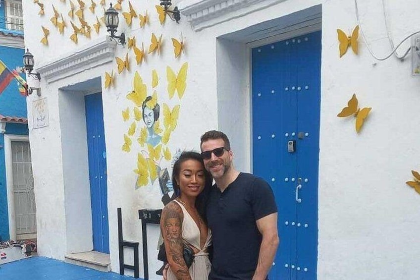 Un edificio con puertas azules y mariposas amarillas pintadas en la pared. 3