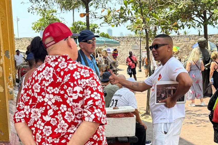 Una persona con camisa y gorra rojos, otra con ropa blanca, y una tercera con ropa blanca y un marco de fotos. 5
