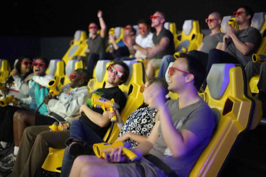 People seated in yellow chairs at an indoor event, some holding yellow objects. 5