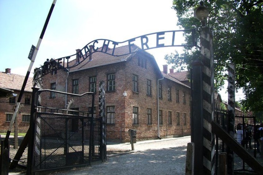 A brick building with a sign that reads 'Mittelbau' and a metal gate. 2