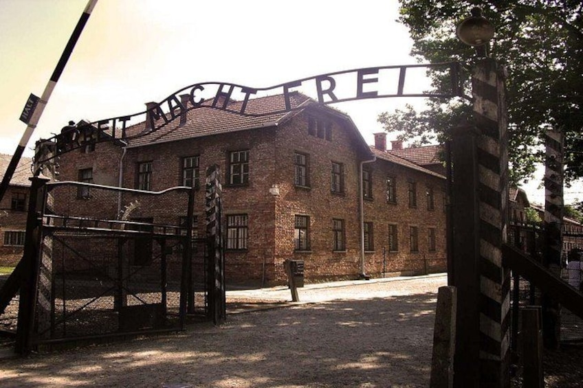 A brick building with a sign that reads 'MACHTREICH' and a metal gate. 2