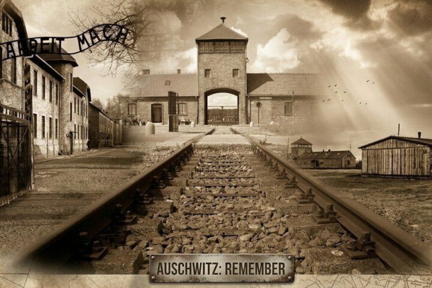 Une voie ferrée menant à un bâtiment sur lequel est affiché un panneau portant l’inscription : « AUSCHWITZ : N’OUBLIONS PAS. » 1