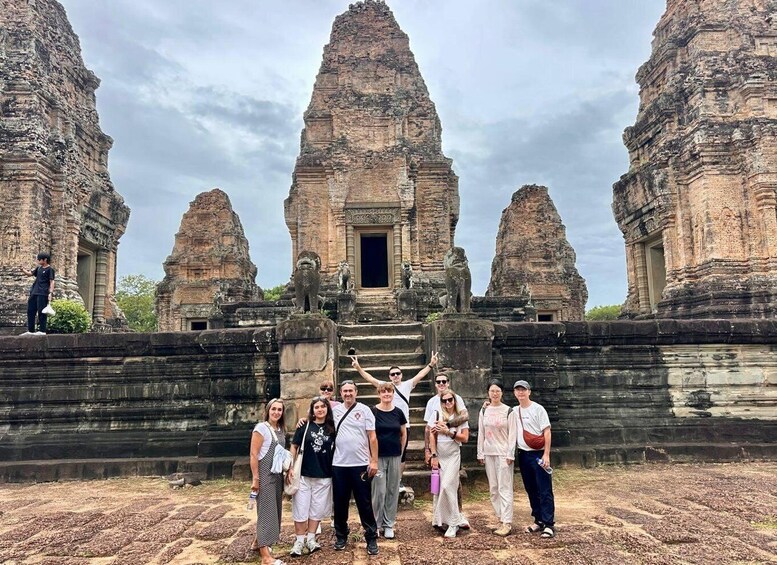 A group of people standing in front of ancient stone structures with multiple towers. 2