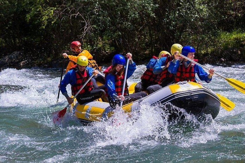 A group of people in a yellow raft navigating a river. 1