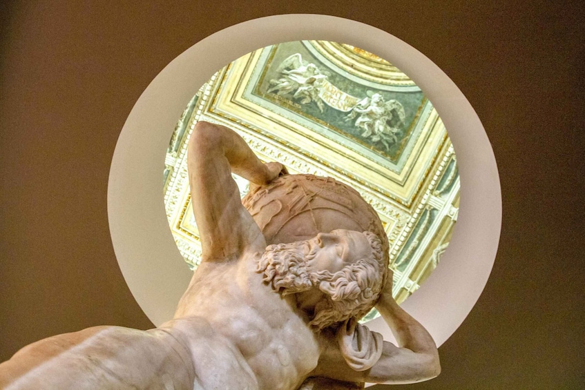 A statue of a muscular man with a beard, holding his head in his hands. 4