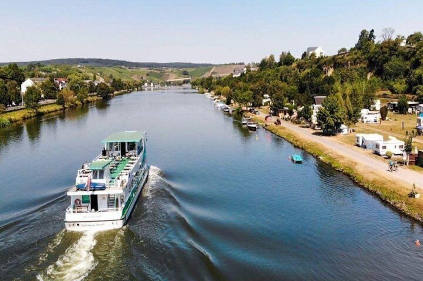 A river with a boat, houses, and greenery along the banks. 5