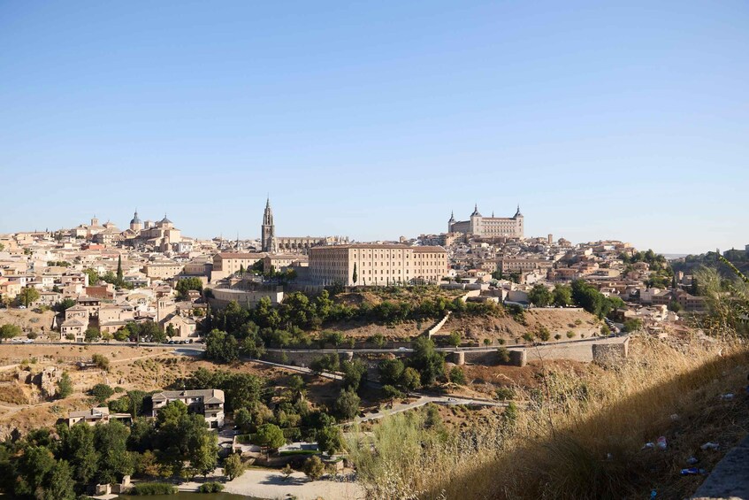 A cityscape with a prominent cathedral, a large building with a tower, and a river. 2