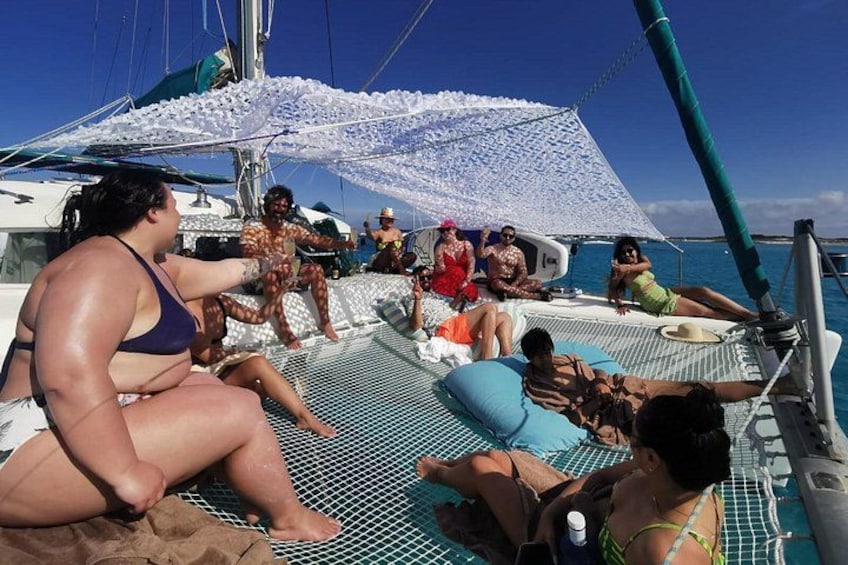 People relaxing on a boat deck with a white canopy overhead. 3