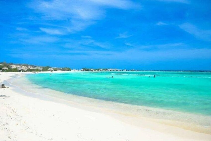 A beach with clear turquoise water and white sand. 1