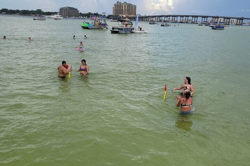 Personas nadando en un cuerpo de agua con barcos y un muelle al fondo. 4