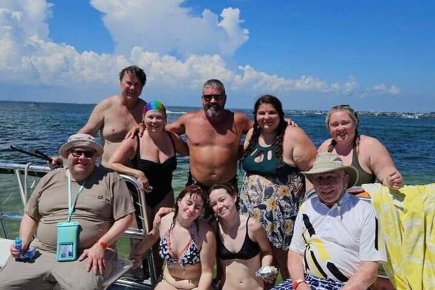 Un grupo de personas en un barco, con un cielo azul despejado y un mar tranquilo al fondo. 2
