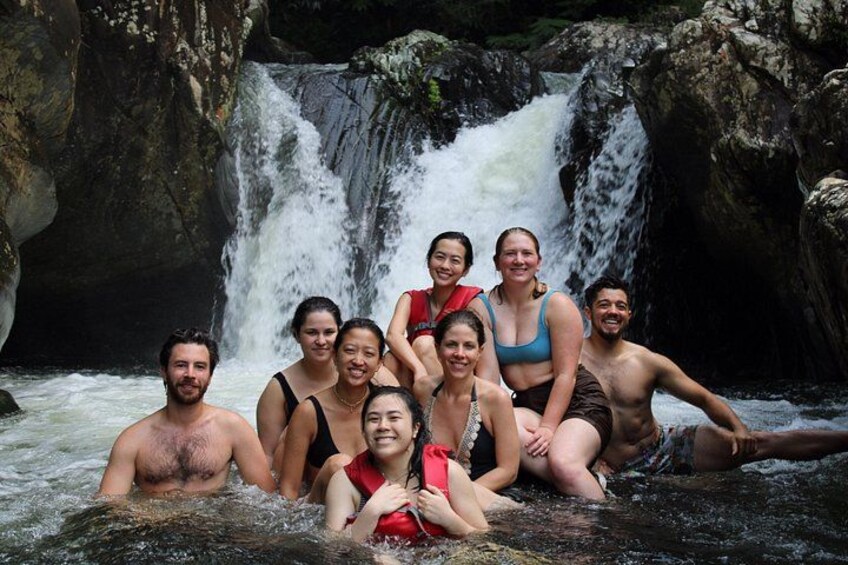 A group of people in a natural setting with a waterfall in the background. 4
