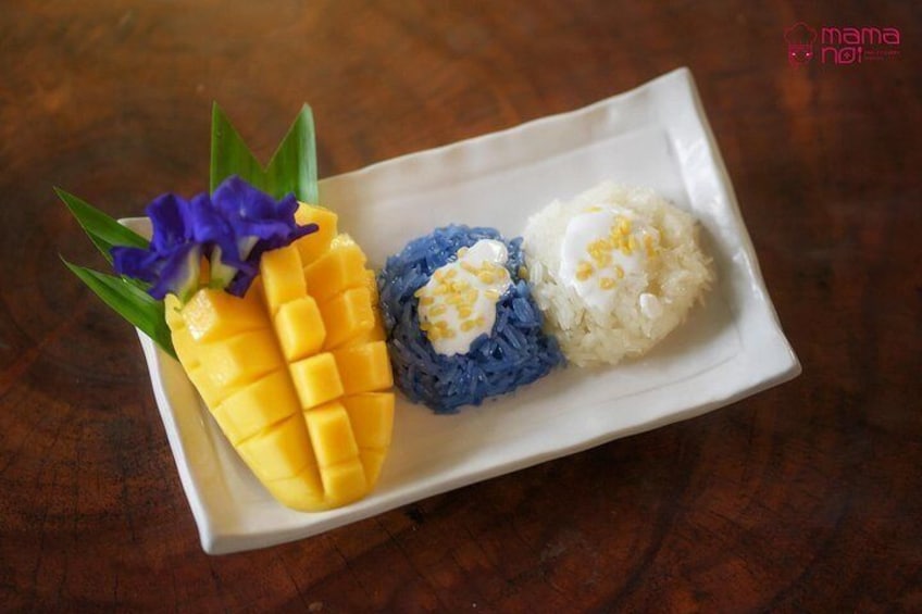 Ein Teller mit Mango, blau gefärbtem Reis und weißem Reis. 3
