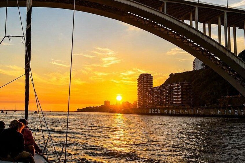Un atardecer sobre un cuerpo de agua, con un puente y edificios al fondo. 4