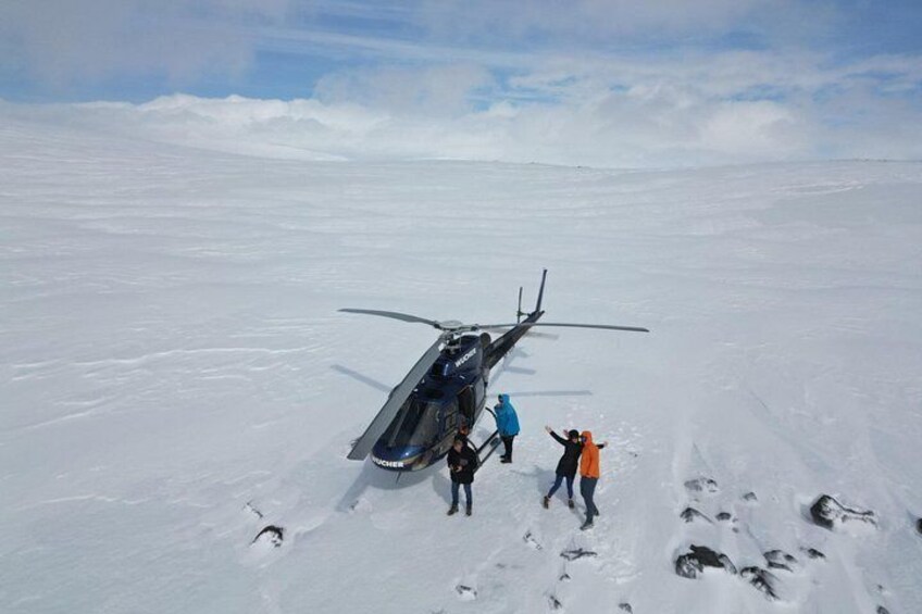 Ein Hubschrauber auf einer verschneiten Fläche, umgeben von Menschen. 5