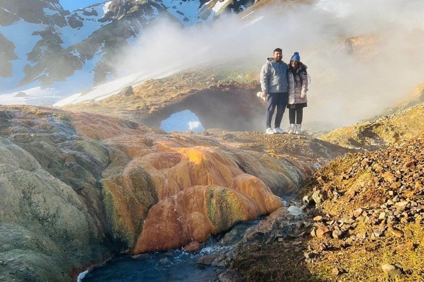 Ett naturligt landskap med en färgstark klippformation, en person som står och en bro. 2