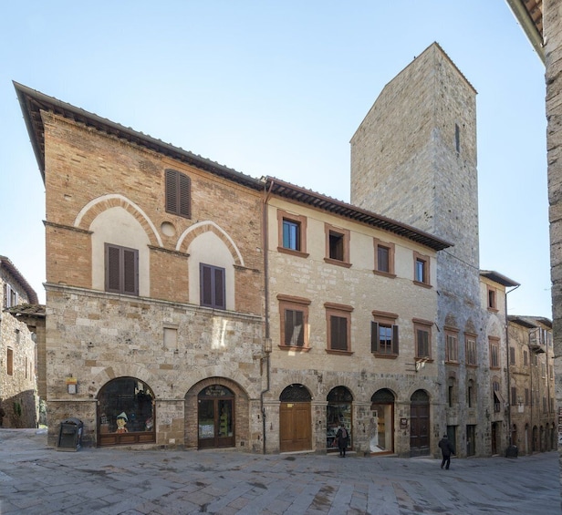 A historic stone building with arched windows and a tall tower. 4
