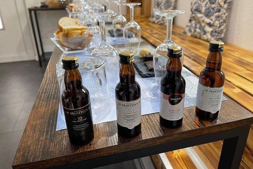 Una mesa de madera con botellas de vino y copas. 1
