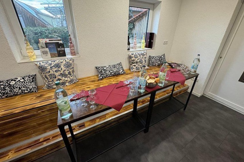 Un comedor con un banco de madera, una mesa de vidrio y varios objetos sobre la mesa. 5