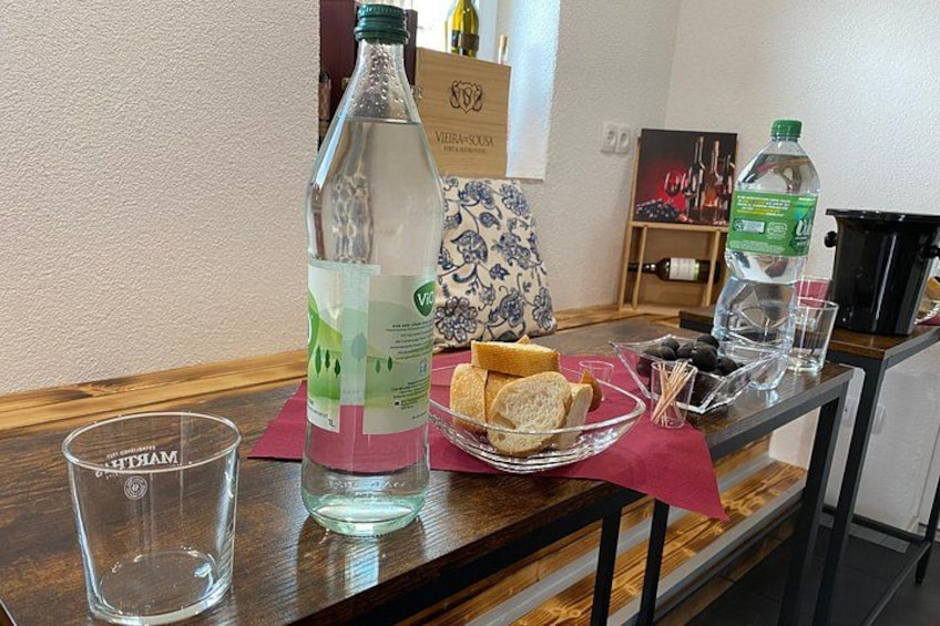Una barra con botellas, vasos y aperitivos. 4