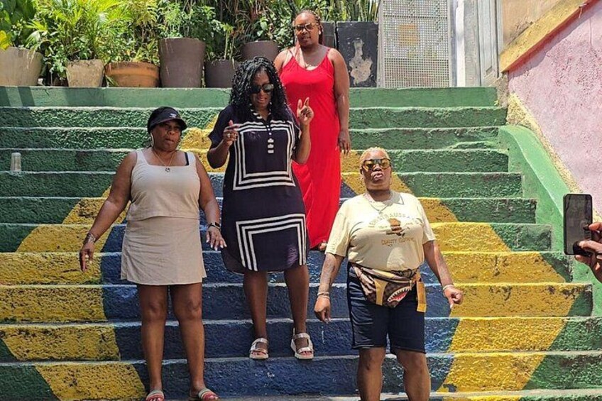 A group of people standing on a staircase with a colorful pattern. 1