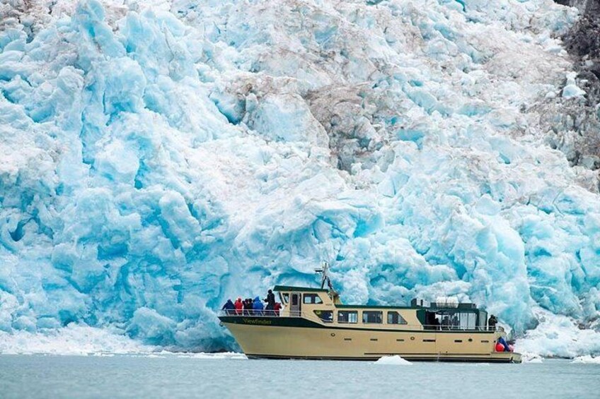 Un barco con pasajeros frente a un glaciar enorme. 2