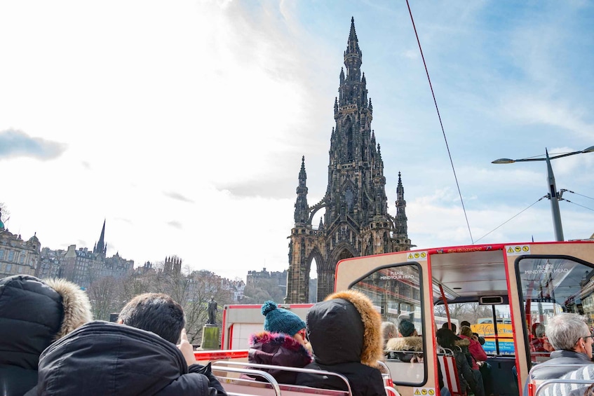 A group of tourists on a bus with a historic cathedral in the background. 4