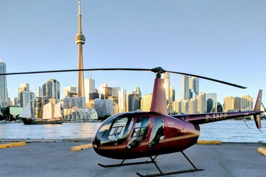 A helicopter parked on a helipad with a city skyline in the background. 1