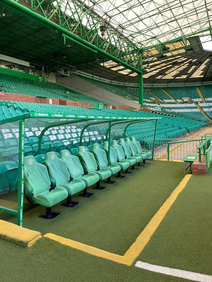 A stadium with green seats and a roof structure. 4