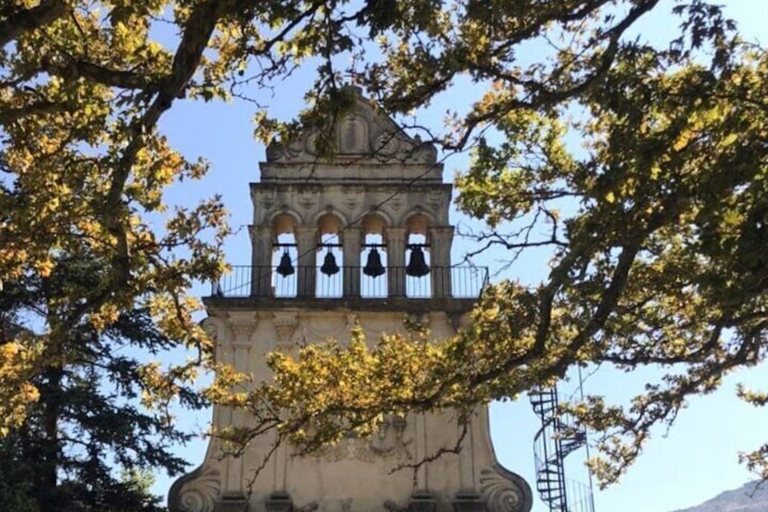 Un clocher doté de fenêtres en arc de cercle et d’un balcon, entouré d’arbres. 4